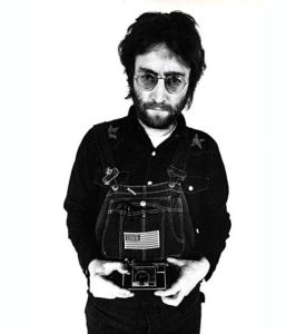 Sporting denim overalls John Lennon truly makes a style statement as always.