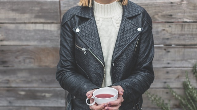 black leather jacket with notch lapels over a cream high neck sweater