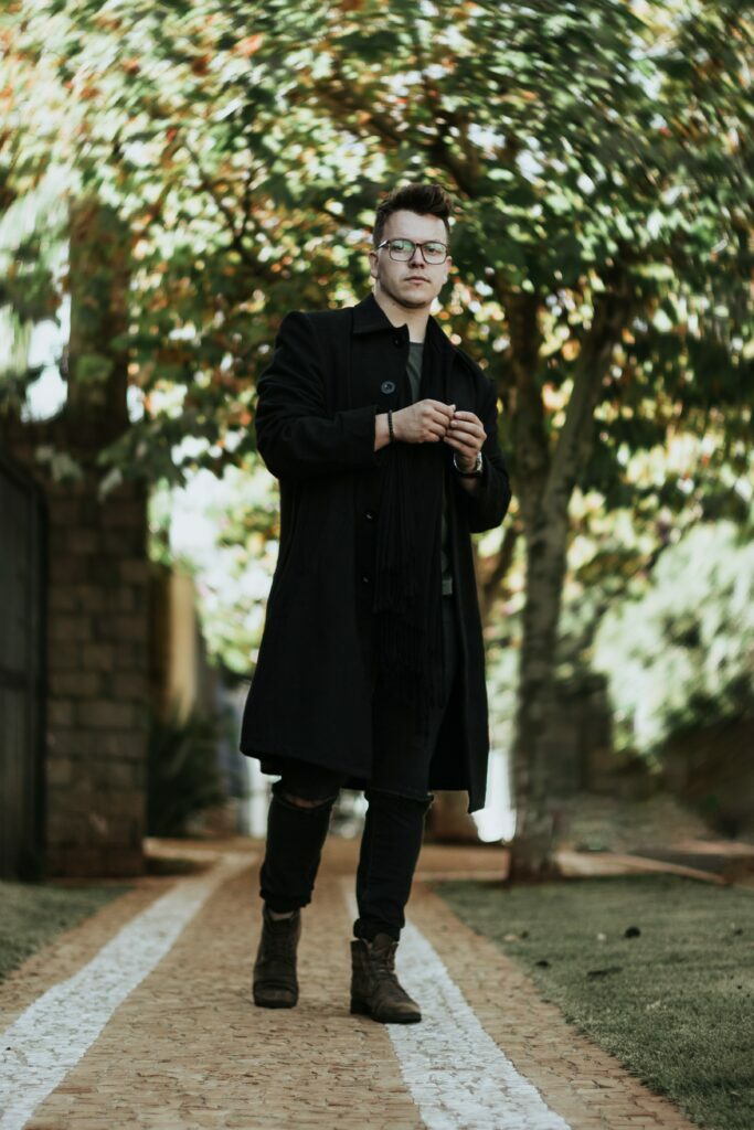 man wearing black trench coat over black jeans
