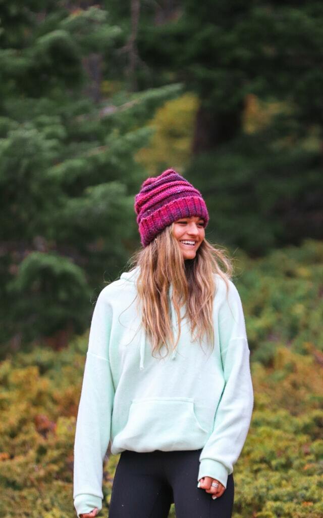 Girl wearing a white sweatshirt and pink  beanie